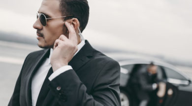 handsome bodyguard of businessman listening message with security earpiece