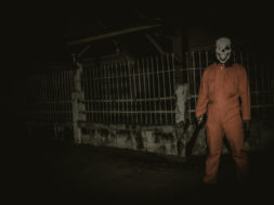 Asian handsome man wear clown mask with weapon at the night scen