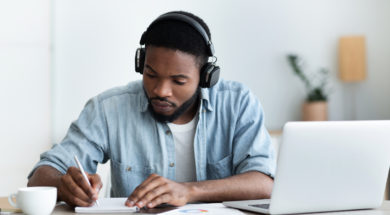 Serious african american student in headphones studying foreign language online