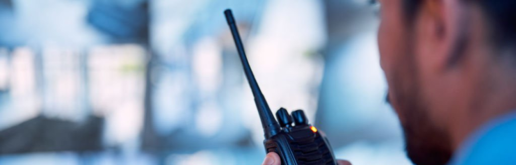 Security guard communicating via walkie-talkie, ensuring a secure environment.