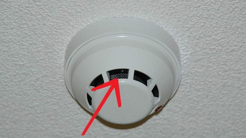 Smoke detector potentially concealing a hidden camera in a hotel room.