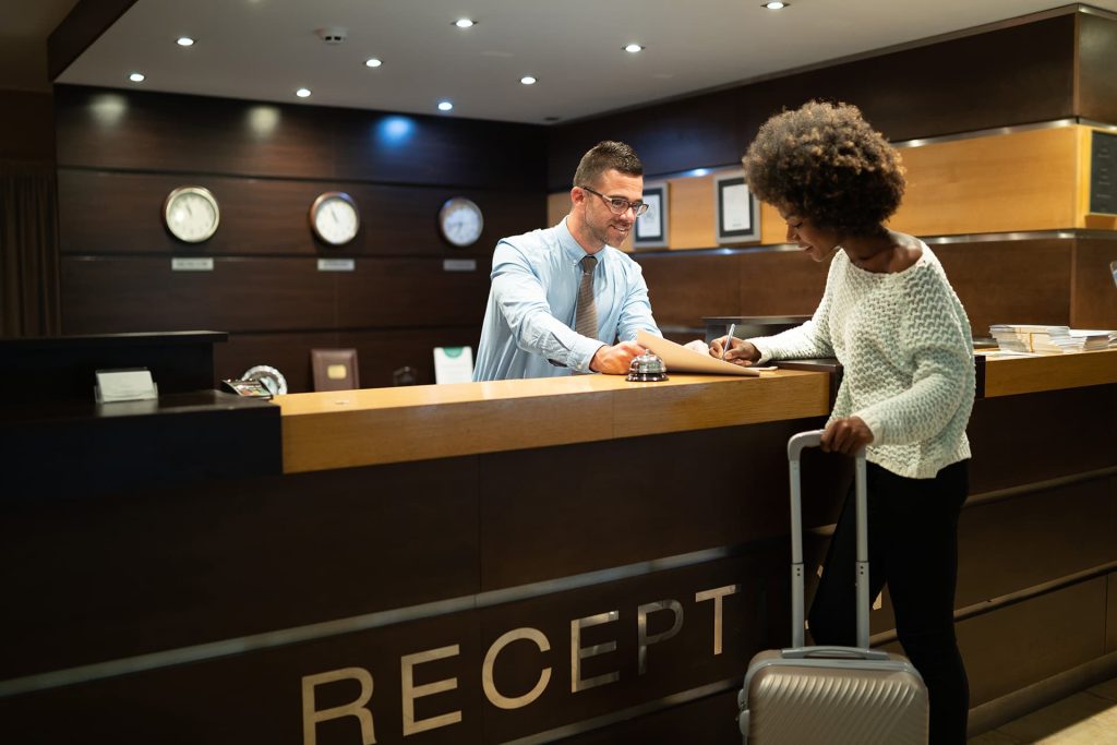 Girl at hotel reception desk during checkout, highlighting the importance of secure and smooth check-out procedures.