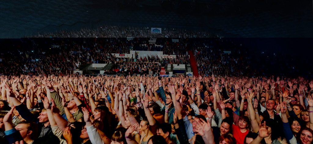 A large excited crowd in a stadium, increasing the risk of crowd surge.