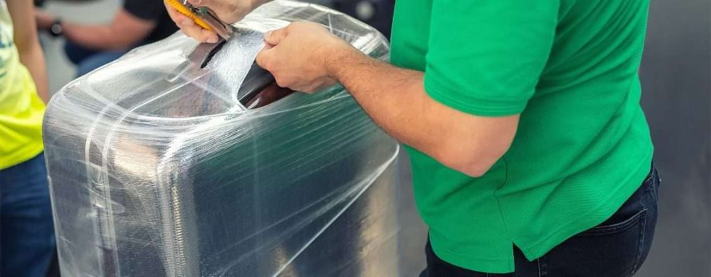 A bag being wrapped at an airport luggage wrapping service to keep it safe and secure