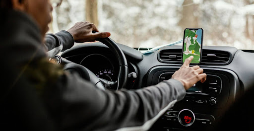 Taxi driver using a map to navigate safely to a passenger's address during a night out in Manchester.