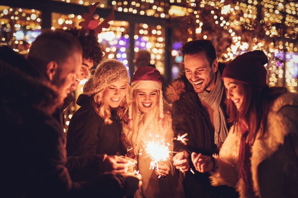 A group of friends holding sparklers on New Year's Eve.