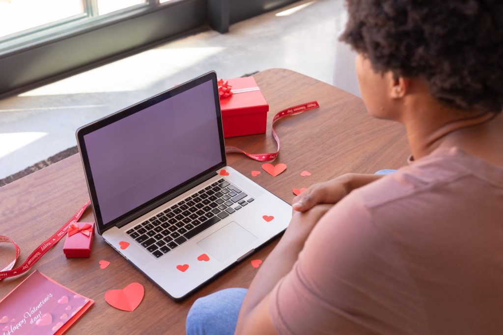 A man sitting in front of a laptop on Valentine's Day.